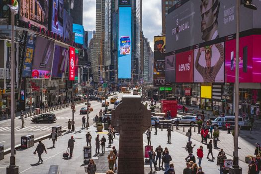 Bustling Times Square, NYC, captures urban life with crowds, traffic and billboards.