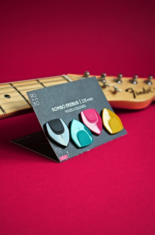 Free A set of vibrant guitar picks displayed on a pink background with a guitar neck. Stock Photo