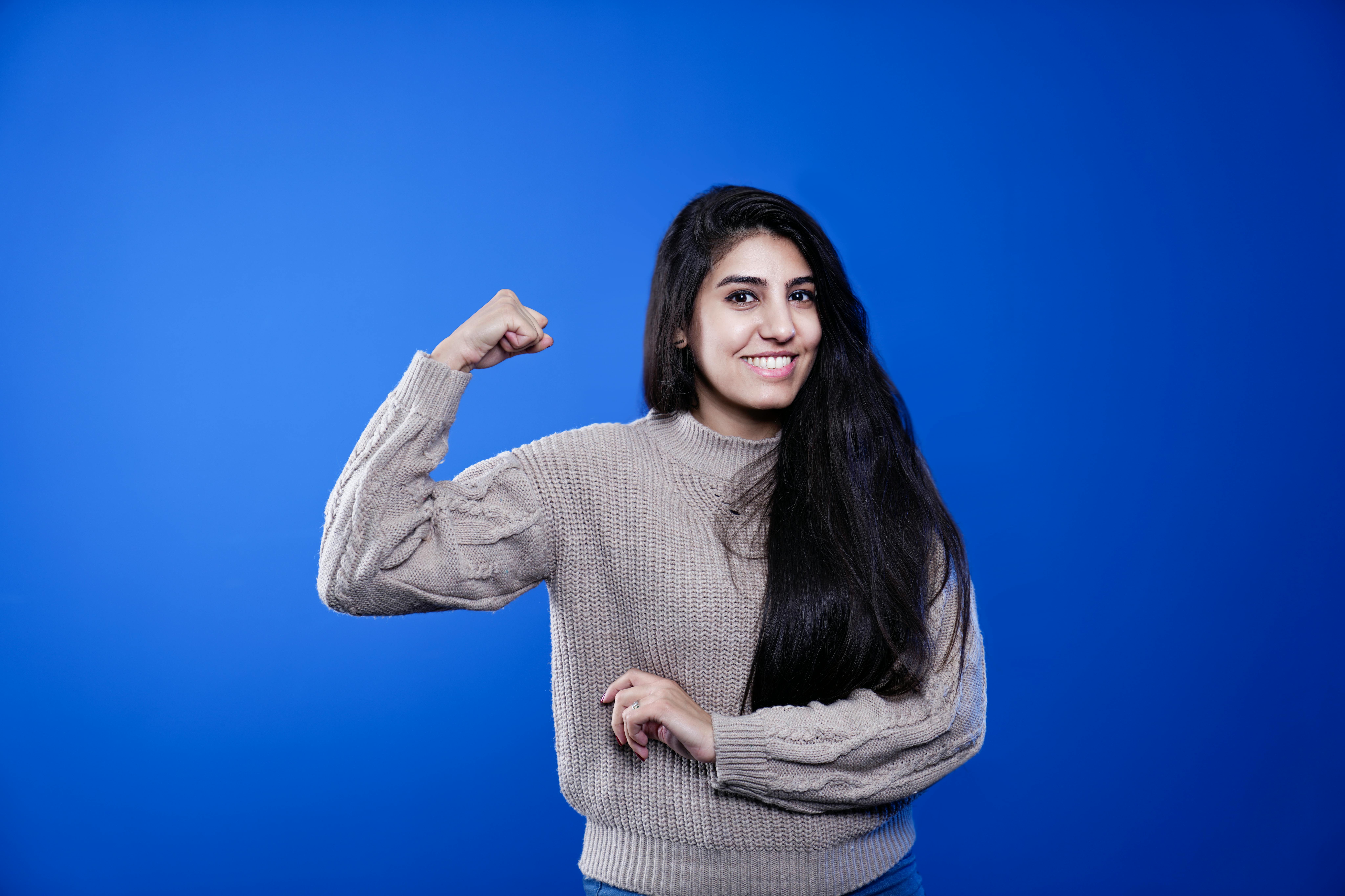 Woman in Blue Background Flexing