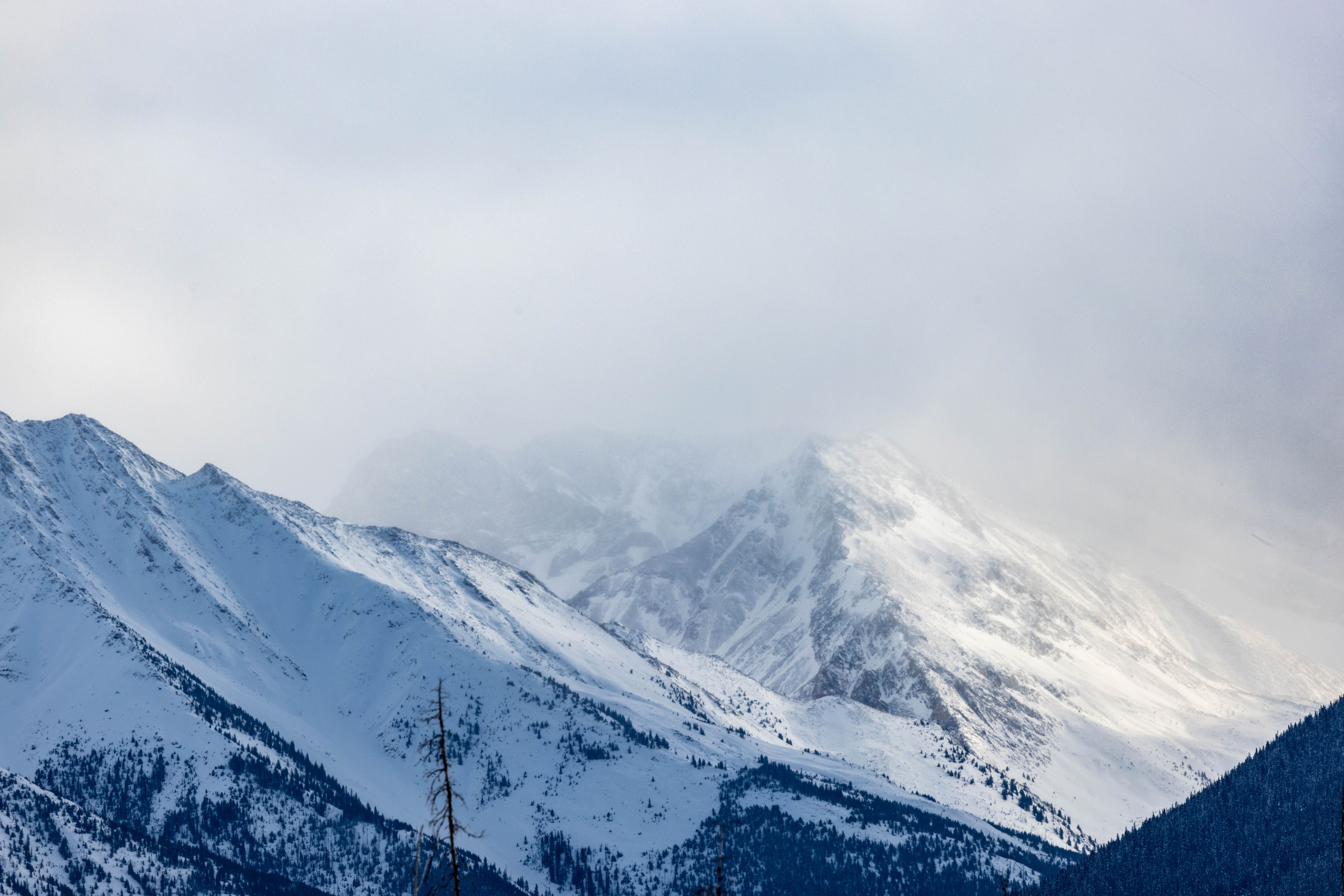 Majestic snow-covered mountains with misty peaks in Banff, Alberta.