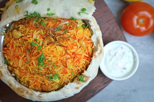 A bowl of rice with vegetables and sauce