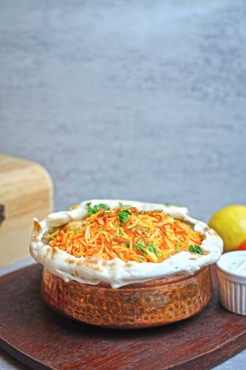 A bowl of food with a spoon and lemon