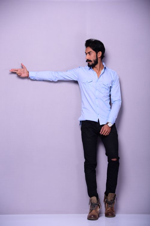 Free A fashionable man striking a pose in a studio setting, exuding confidence and style. Stock Photo