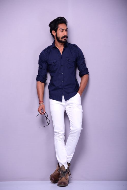 Free Fashionable man in blue shirt with glasses, posing confidently against a neutral background. Stock Photo