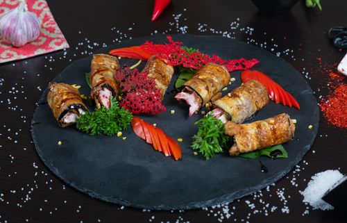 Free Exquisite sushi rolls with fresh vegetables elegantly presented on a dark platter. Stock Photo