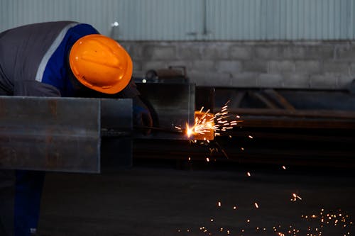 A worker welding metal with sparks