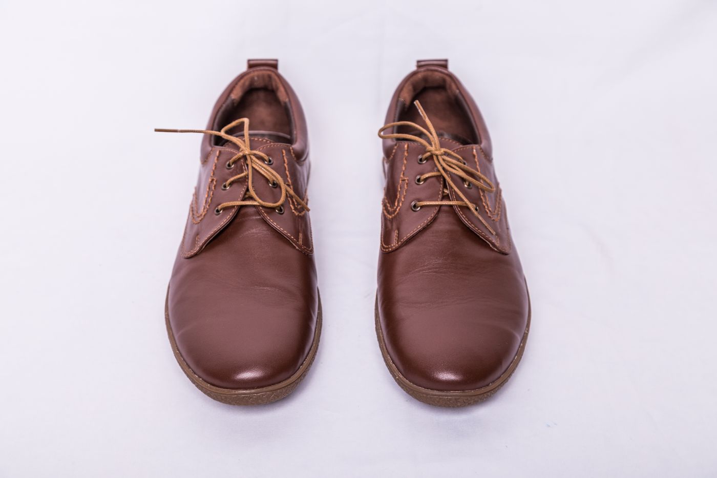 Pair of brown leather derby shoes photographed head-on — photo by Collab Media on Pexels
