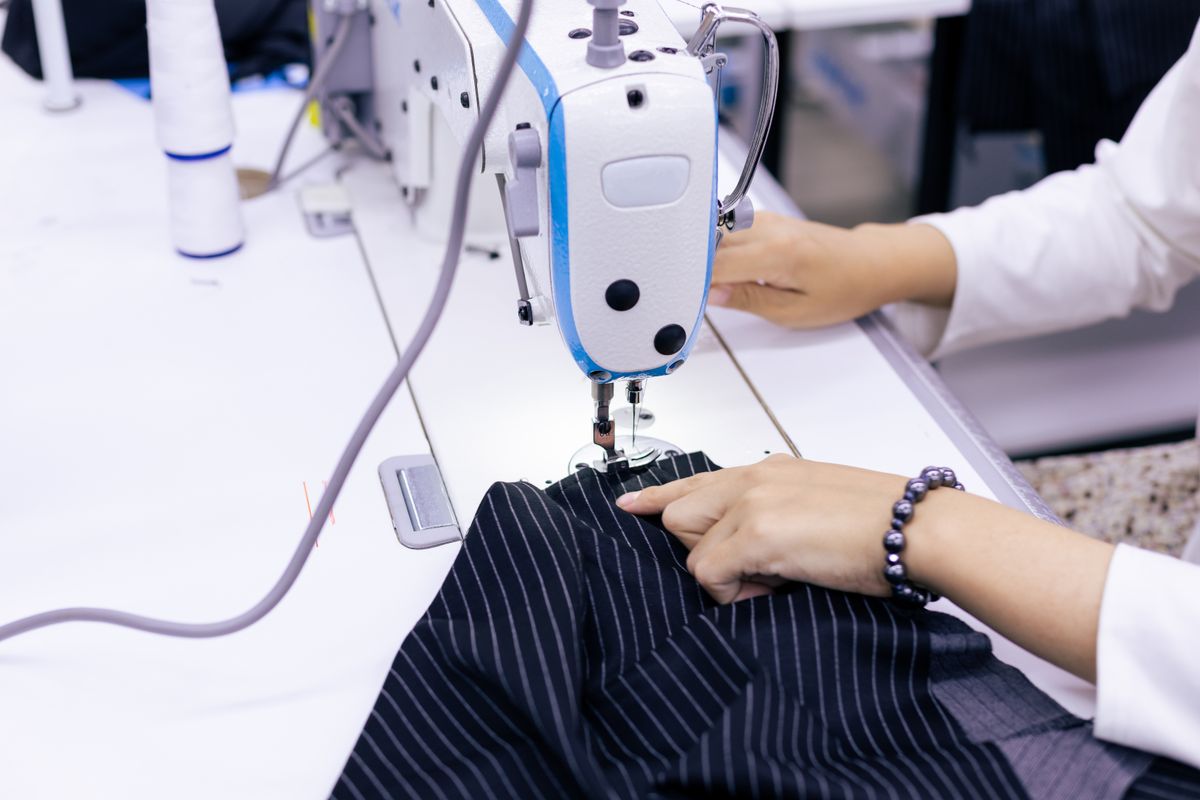 Close-up of fabric being guided through a sewing machine
