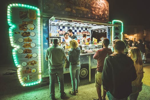 People enjoying vibrant street food at a food truck in Santiago de Compostela by night.