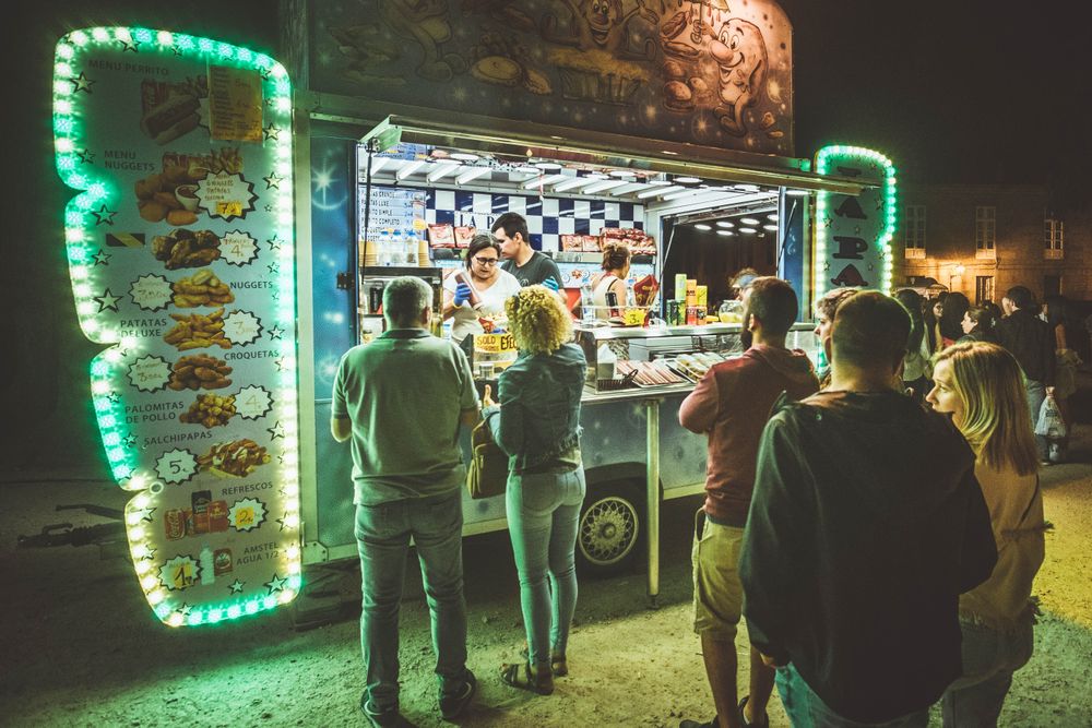 The Fuego Seoul truck glowing at night with a line of customers