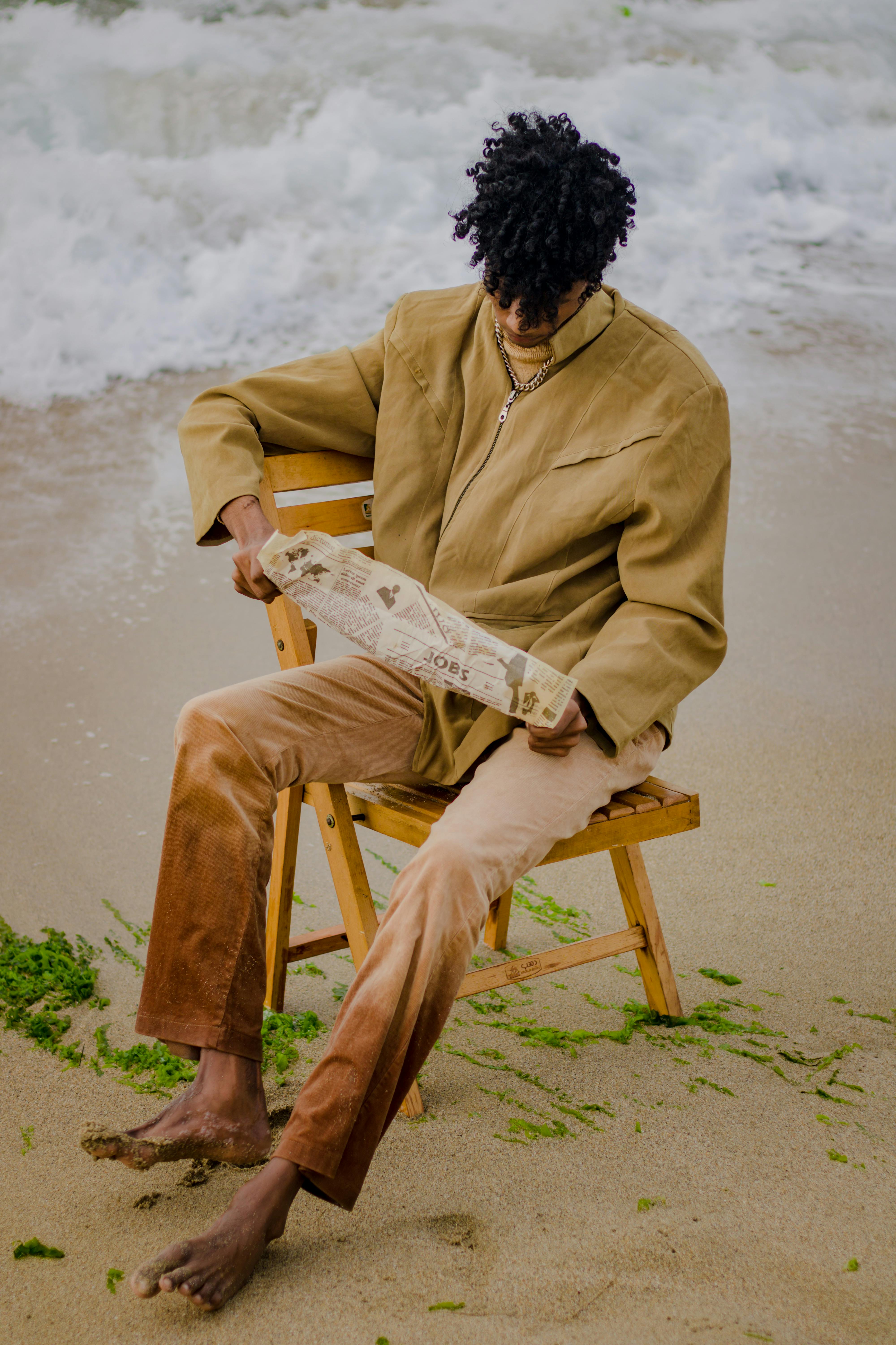 man sitting on a chair on a beach