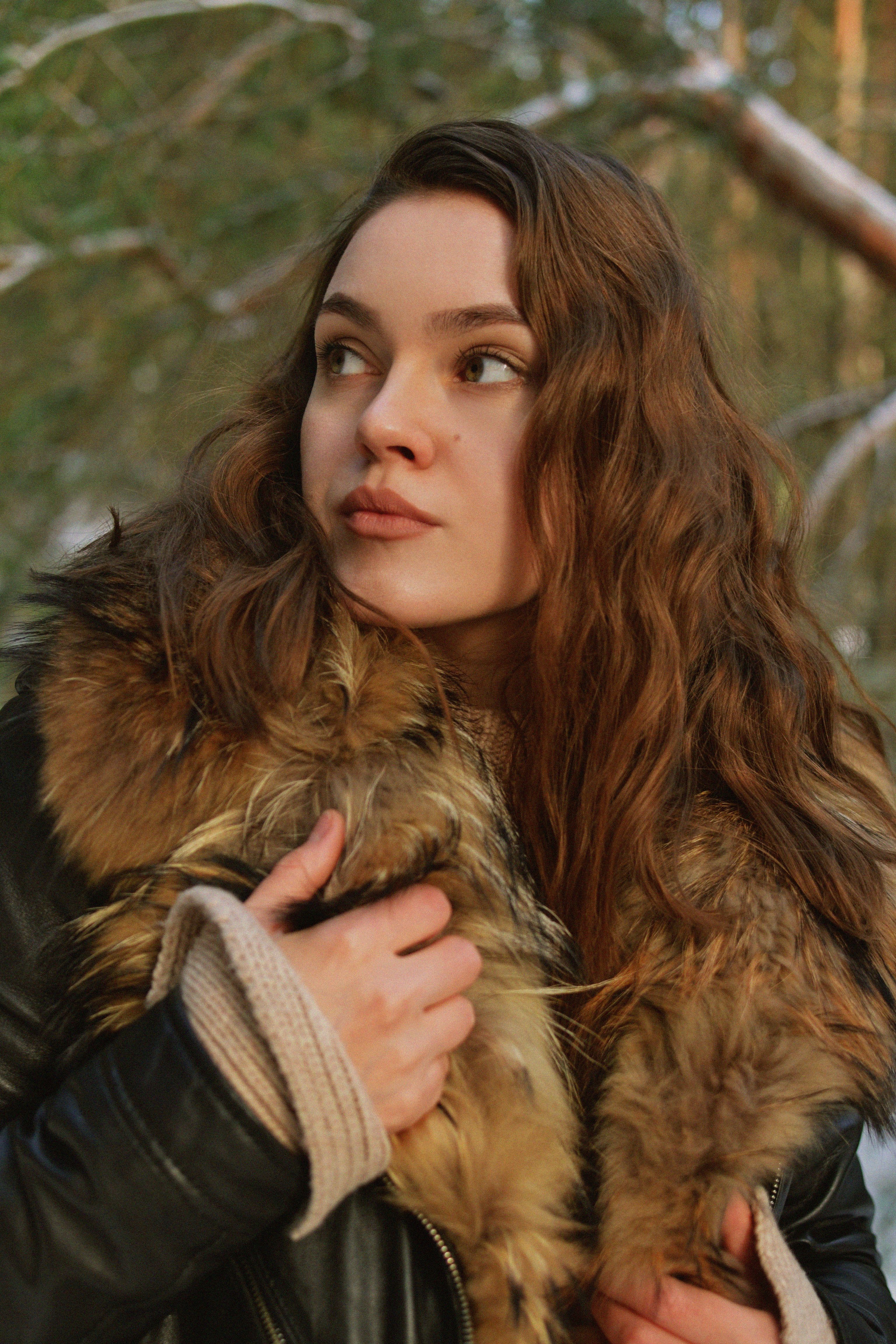 Portrait of a woman in a fur-trimmed coat outdoors in the winter season.