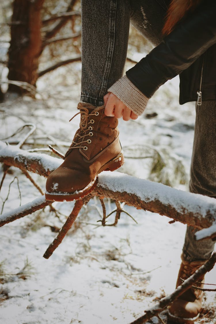 Close-up Of Woman Wearing Boots In Winter Forest