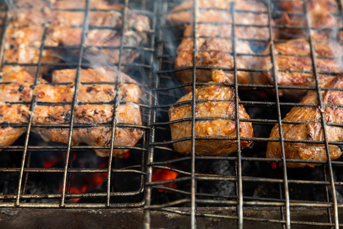 Close-Up Photo of Man Cooking Meat · Free Stock Photo