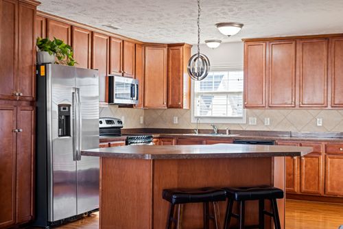 Free Spacious modern kitchen interior featuring wooden cabinets and island. Stock Photo