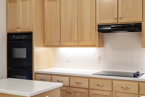 Brown Wooden Kitchen Cabinets and Black Kitchen Appliances