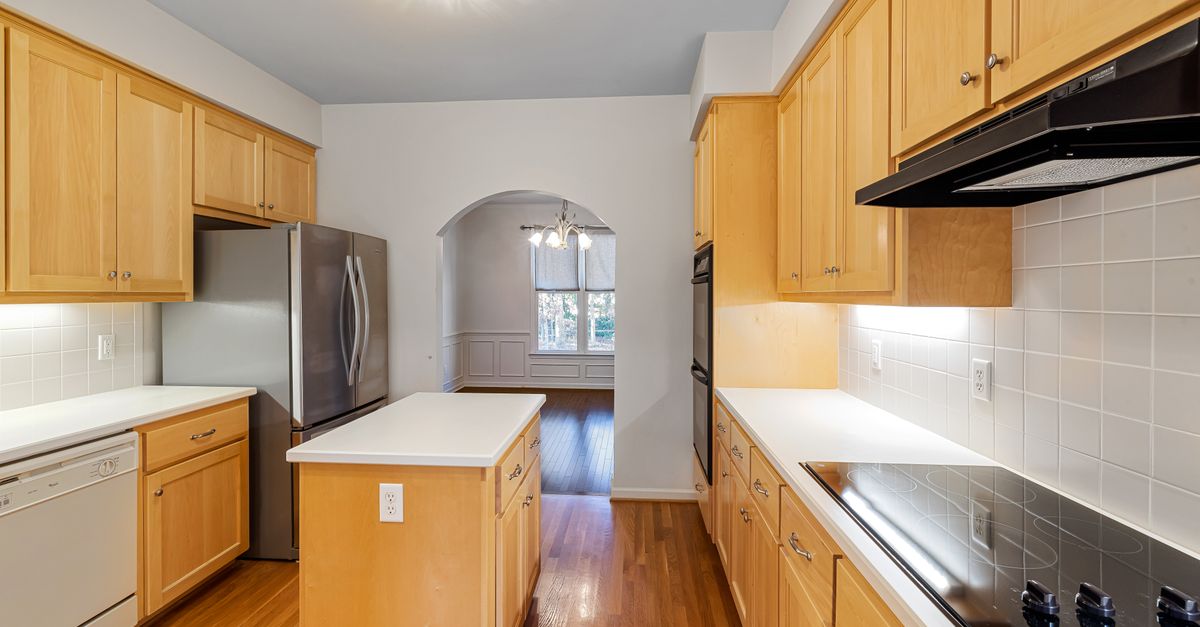 Spacious kitchen featuring wooden cabinets, a central island, and stainless steel appliances.