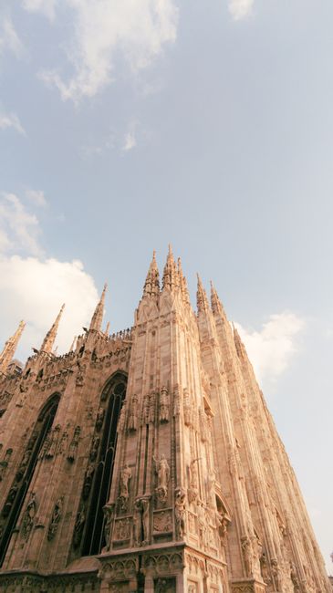 A breathtaking low-angle shot of the iconic Milan Cathedral showcasing its Gothic architecture against a clear sky.