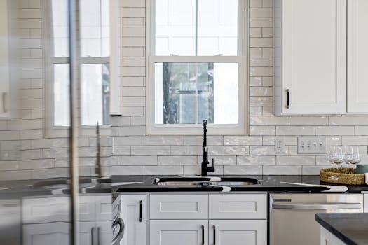 Sleek kitchen with black countertops, white cabinets, and modern design elements.