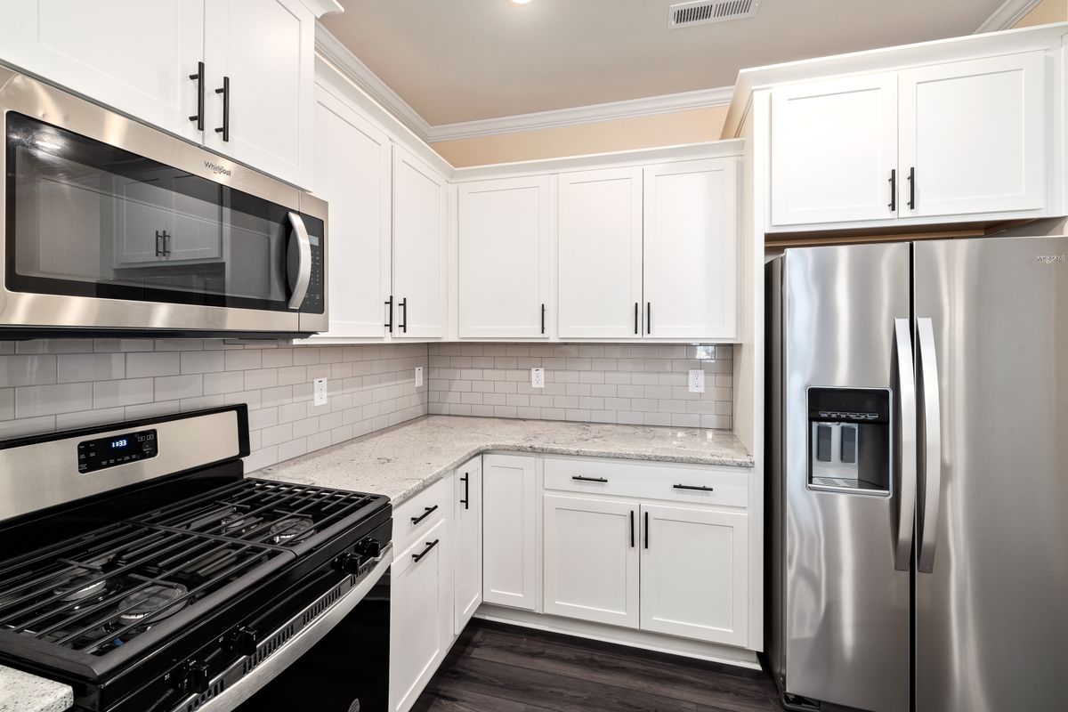 Updated kitchen with durable countertops and stainless steel appliances