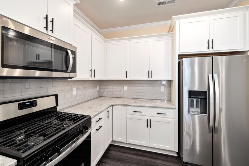 White laminate modular kitchen with stainless appliances