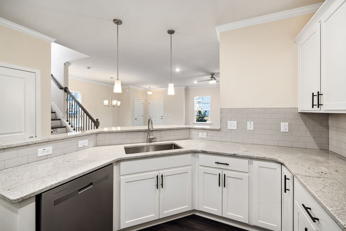 Modern white kitchen with granite countertop and pendant lighting