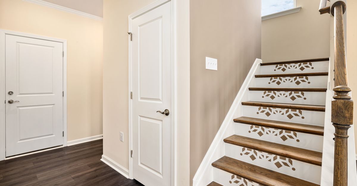 Spacious modern home interior featuring a creatively designed staircase with light colors.