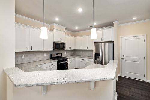 Free Sleek contemporary kitchen featuring white cabinets and granite countertops. Stock Photo