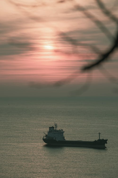 A Silhouetted Bulk Carrier on the Sea at Sunset 