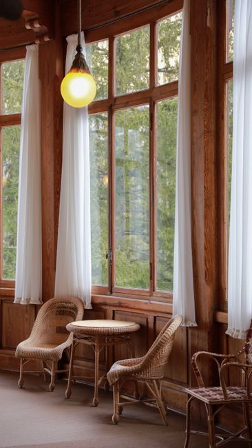 Charming indoor setting in Gressoney-Saint-Jean featuring rustic rattan chairs and wooden decor.