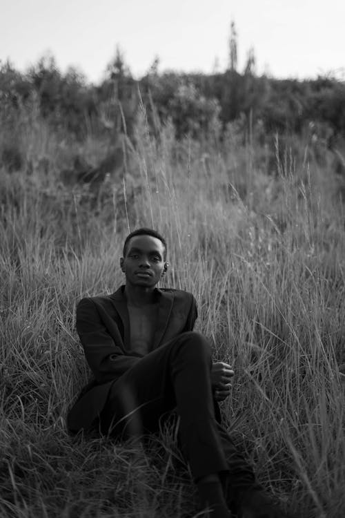 Free Man Sitting and Posing on Grasses in Black and White Stock Photo