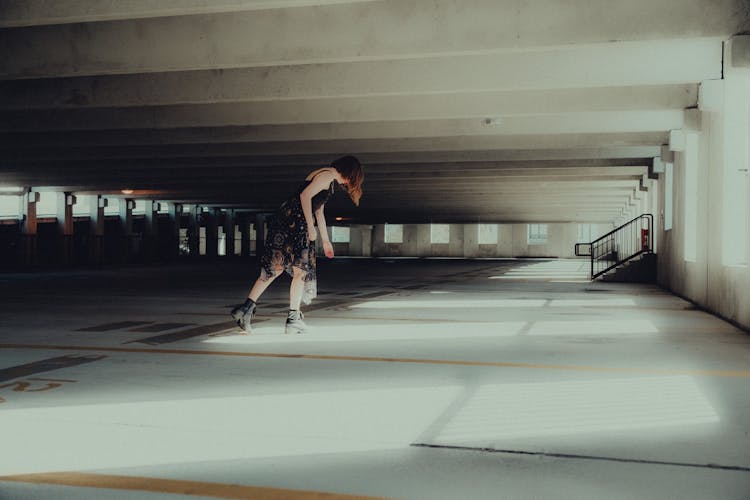 Woman In Black Dress Walking In An Empty Basement Of A Building