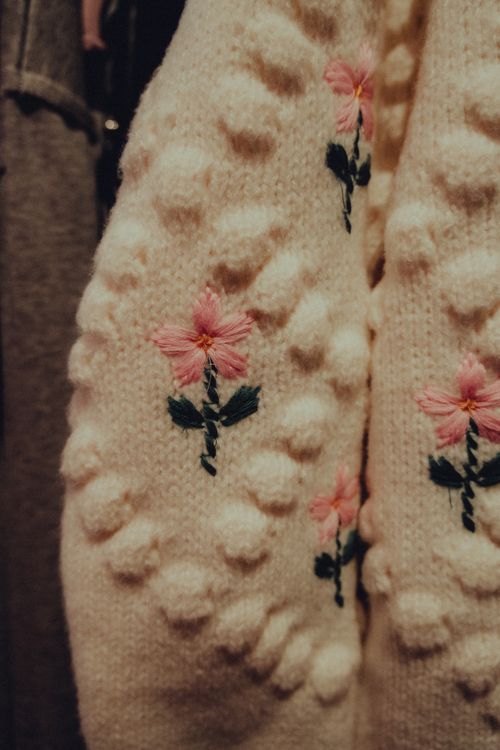 Free Detailed close-up of a knitted sweater with floral embroidery, warm tones. Stock Photo