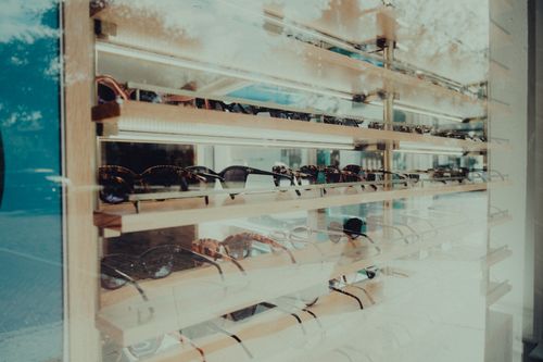 Free Showcase of stylish sunglasses in a retail window display, perfect for fashion and shopping themes. Stock Photo