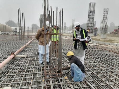 Foto profissional grátis de capacetes, Edifício - Atividade, homens