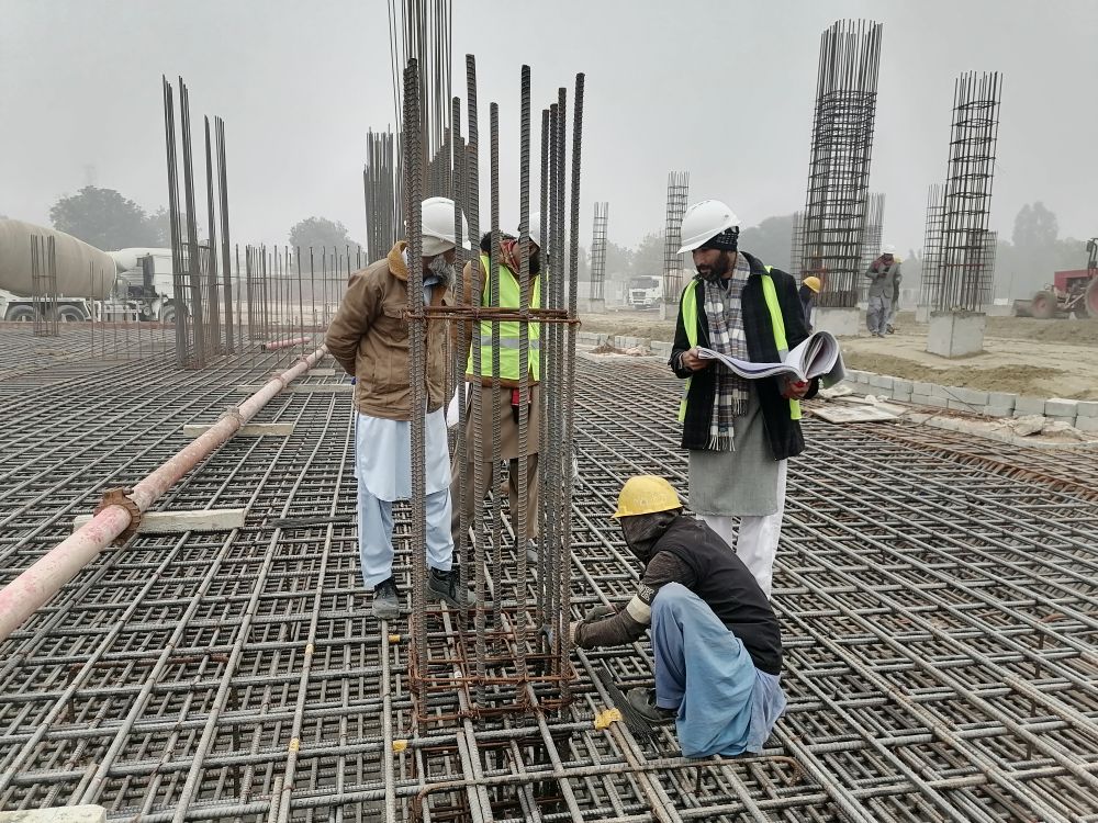 Engineers inspecting a steel structure on a construction site in Punjab