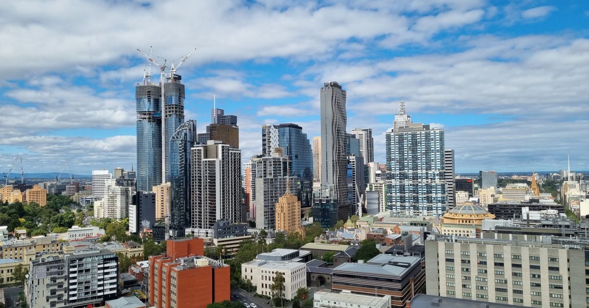 Panoramic view of Melbourne's urban skyline showcasing modern skyscrapers under a vibrant sky.