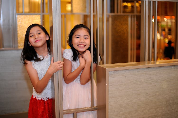 Little Girls Playing Beside A Railing