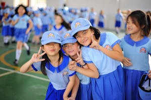 Schoolgirls in Uniforms Posing for a Photo in a Gym 