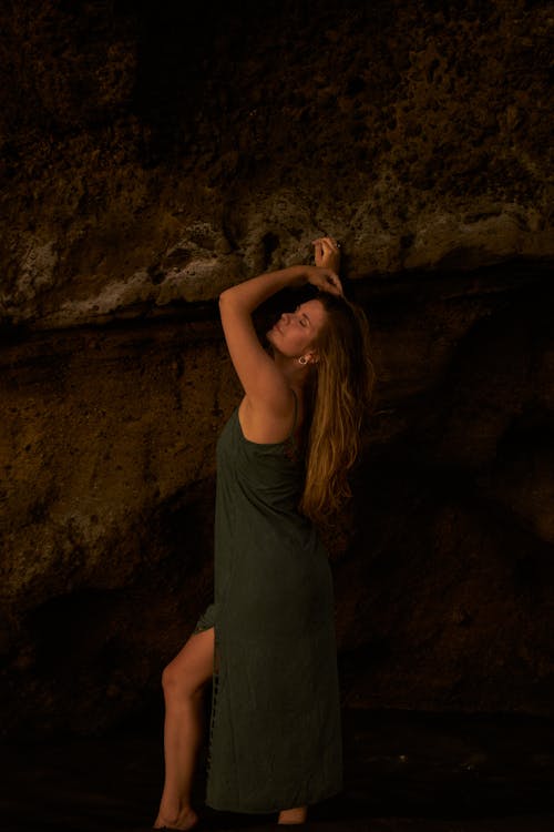 Woman in a Green Dress Posing in a Cave 