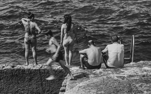 Free A group enjoying a summer day by the sea, captured in artistic black and white. Stock Photo