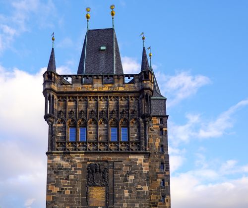 Free Gothic architectural tower in Prague, Czechia set against a clear blue sky, showcasing historical grandeur. Stock Photo