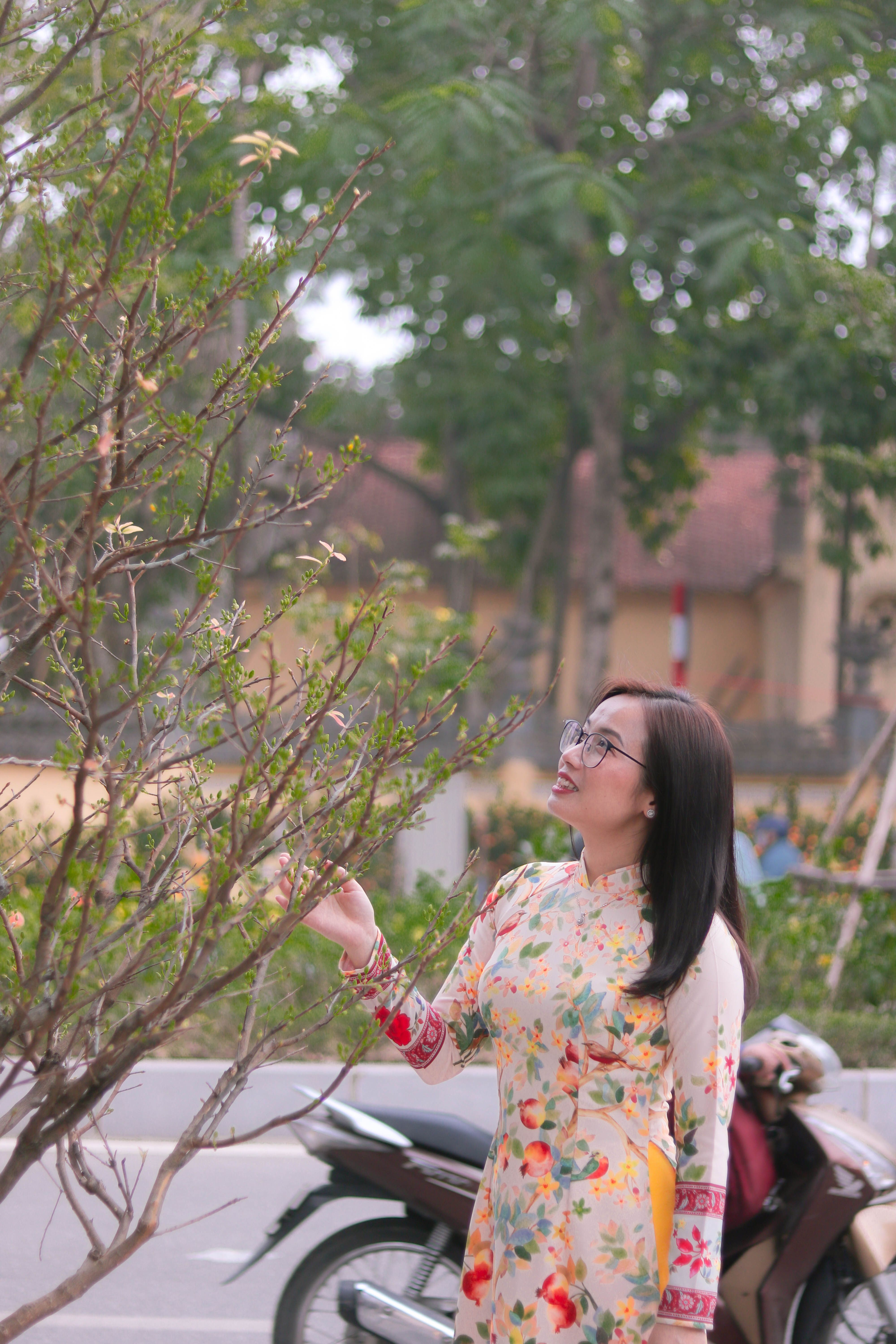 Woman in Dress Standing near Motorcycle and Tree · Free Stock Photo