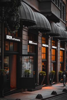 Ambient evening glow on city café with inviting awnings and street view.