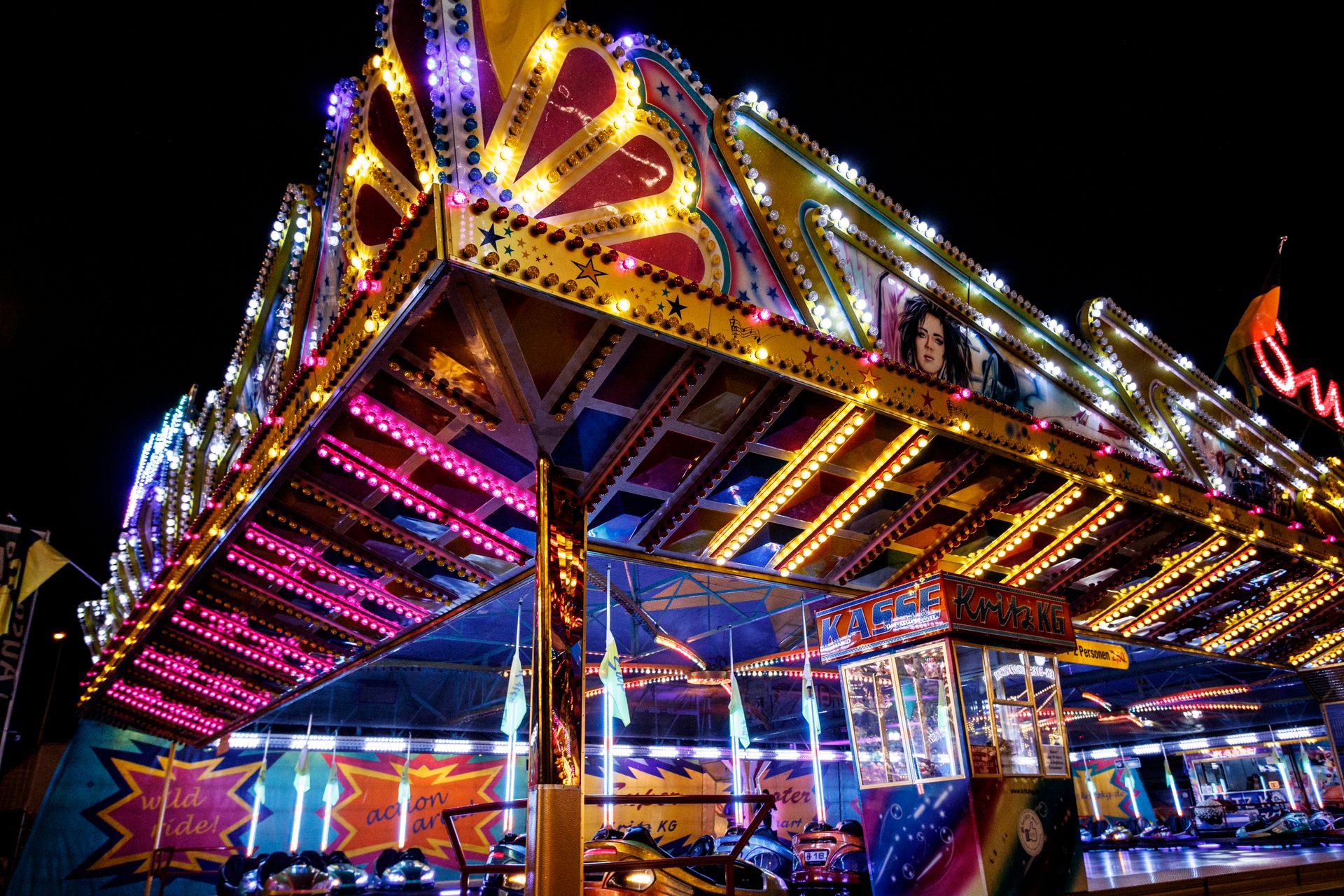 Colorful illuminated amusement ride at night showcasing vibrant lights and attractions.