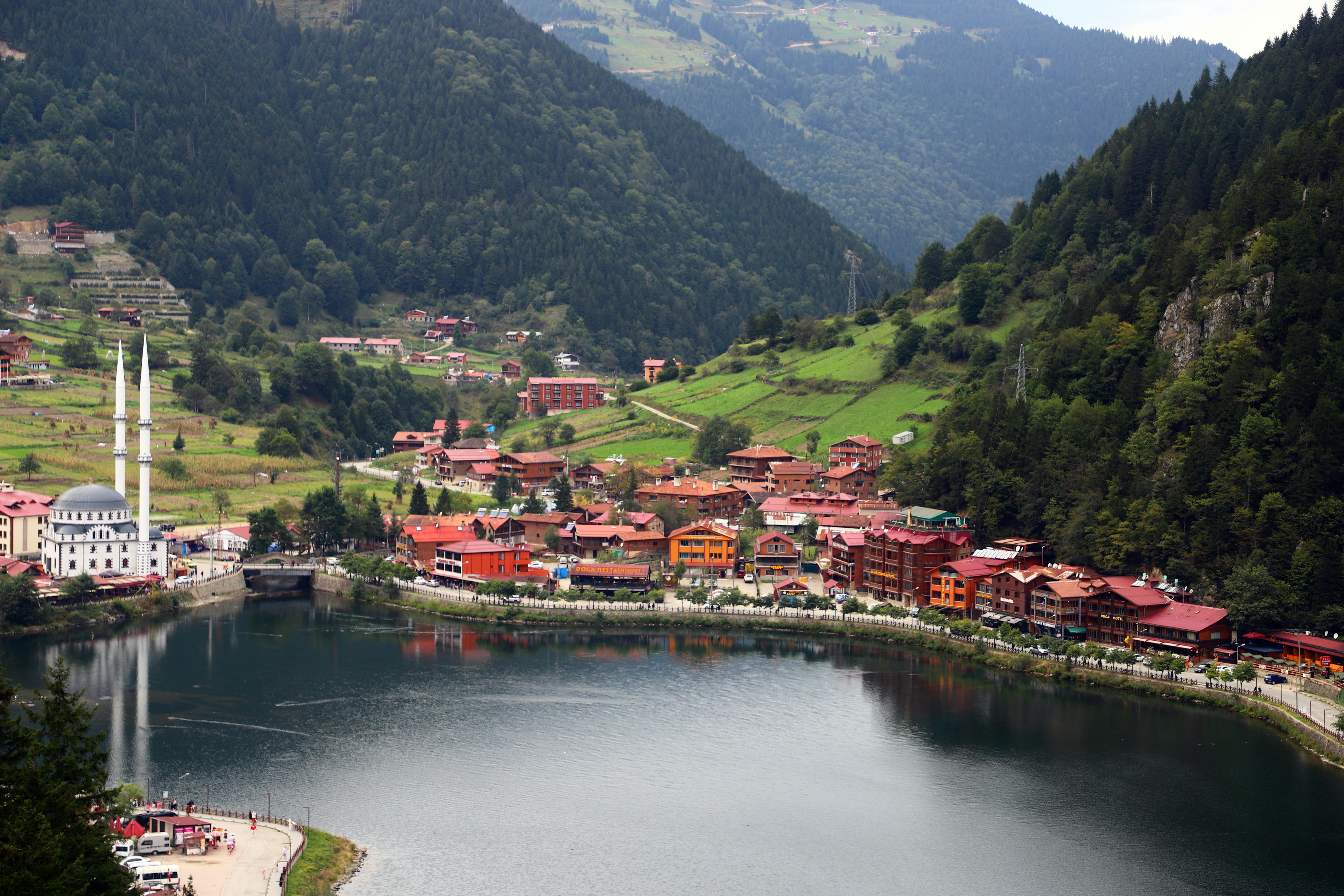 Picturesque Uzungöl lake with surrounding mountains and town in Turkey.