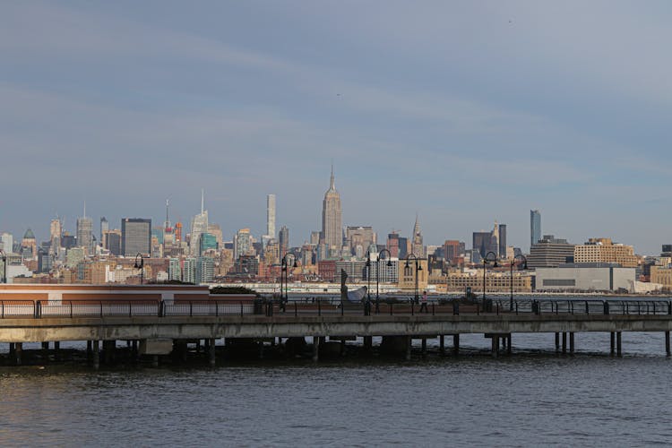 Pier In Water On Cityscape Background