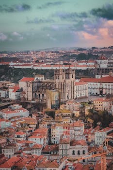 Stunning aerial shot of Porto, Portugal featuring the historic Porto Cathedral amidst colorful city rooftops.