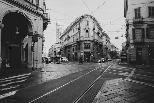 Black and white photo capturing the historical architecture and vibrant street life of Torino, Italy.