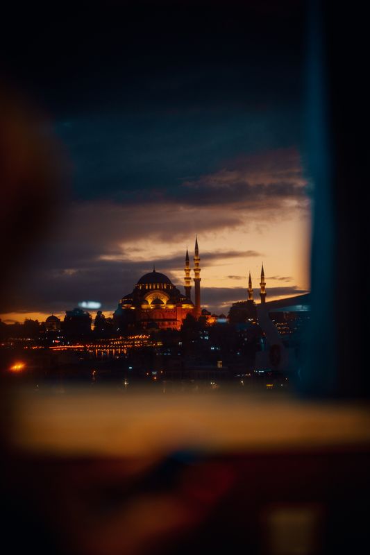 Dramatik bir alacakaranlık gökyüzü altında ışıklandırılmış bir cami